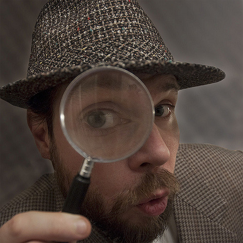 detective holding magnifying glass